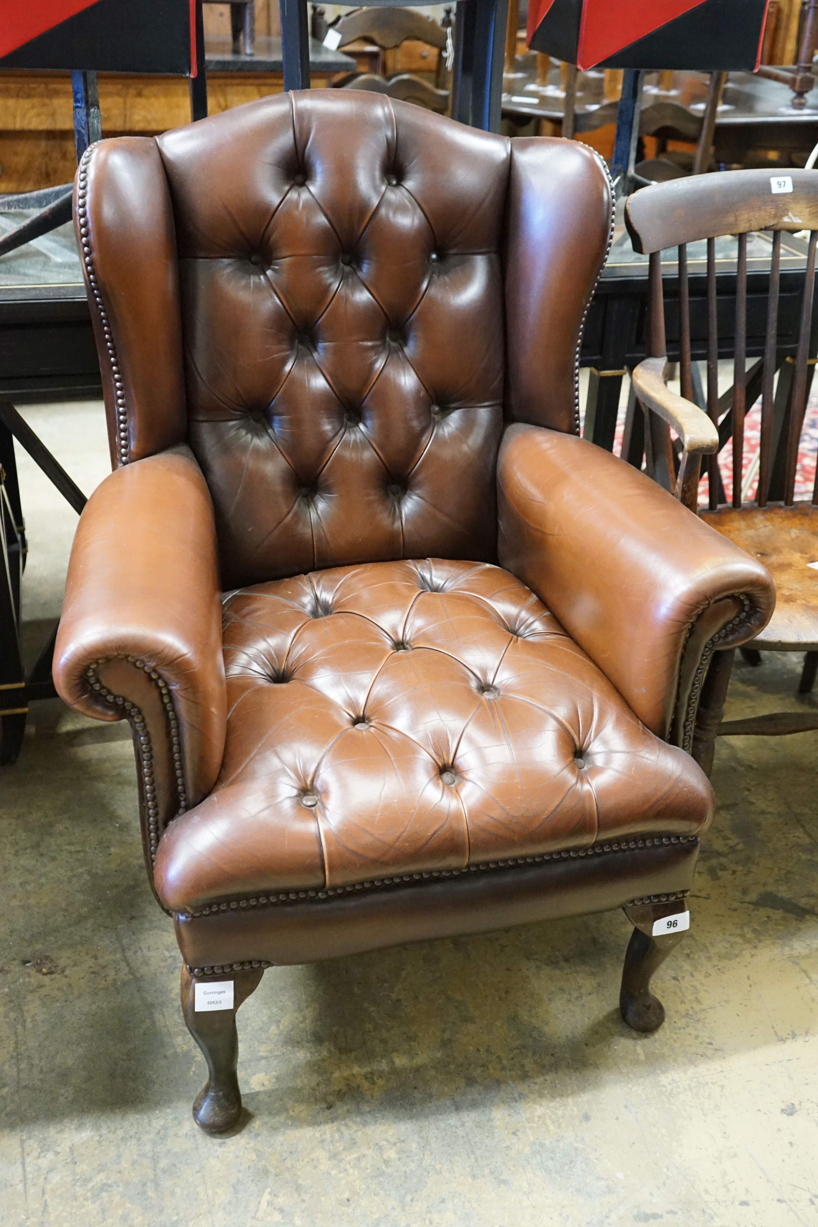 A Victorian style buttoned brown leather-upholstered wing armchair, width 77cm, depth 62cm, height 102cm